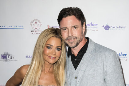 Denise Richards and her husband Aaron Phypers on a step and repeat for a charity gala.
