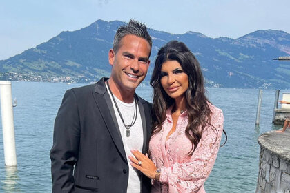 Louie Ruelas and Teresa Giudice pose together in front of a lake and mountain.