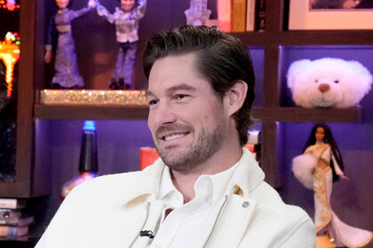 Craig Conover wearing a white button down and a white jacket while a guest on WWHL.