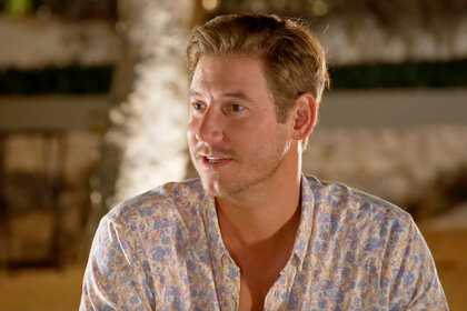 Austen Kroll sits on a couch on the beach on Southern Charm Season 9 Episode 11