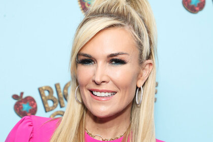 Tinsley Mortimer posing in a pink outfit in front of a step and repeat.