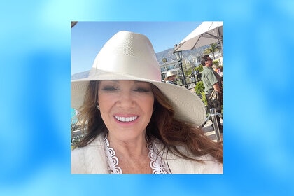 Lisa Vanderpump smiling while wearing a white hat at Rosewood Miramar Beach in California.