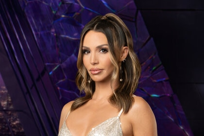 Scheana Shay wearing a sparkly silver bralette while in a purple room overlooking LA.