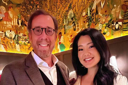 Crystal Kung Minkoff and Rob Minkoff smiling next to each other in a restaurant.