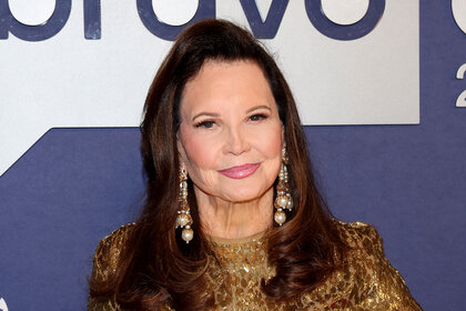 Patricia Altschul standing in front of a step and repeat at BravoCon 2023.