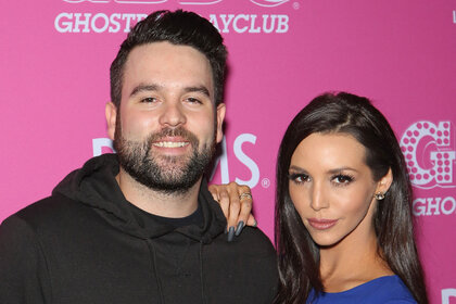 Scheana Shay and Mike Shay posing together in front of a step and repeat.