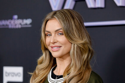 Lala Kent smiling in front of a step and repeat.