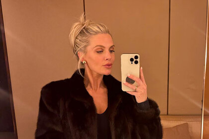Madison LeCroy wearing a fur coat in front of a mirror.