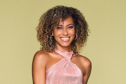 Shanice Henderson wearing a pink halter dress in front of a light brown backdrop