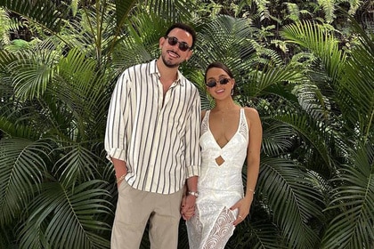 Alexia Umansky with her boyfriend Jake Zingerman in front of a bush of palms