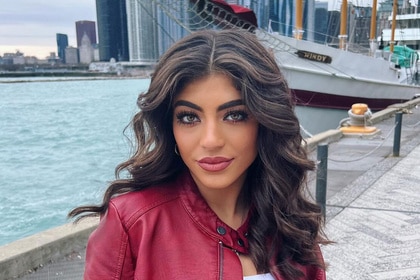 Milania Giudice posing on a pier in front of a boat.