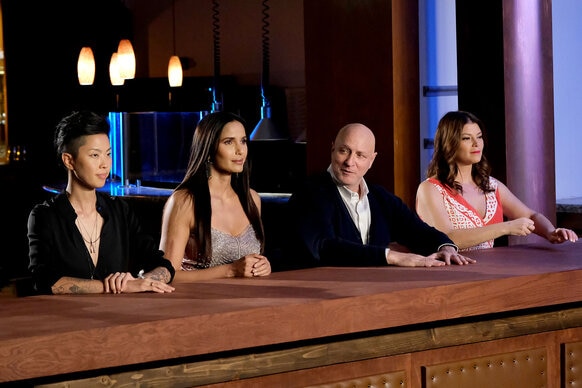 Kristen Kish, Padma Lakshmi, Tom Colicchio and Gail Simmons sitting at the judges table during Season 19 of Top Chef.
