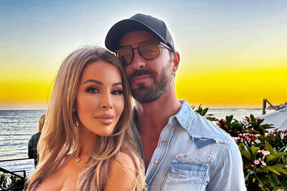 Lisa Hochstein and Jody Glidden pose together in front of a sunset in California.