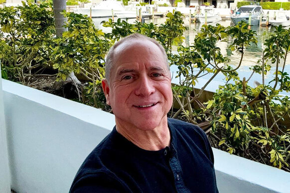 Captain Glenn Shephard smiling in front of a marina in Florida.