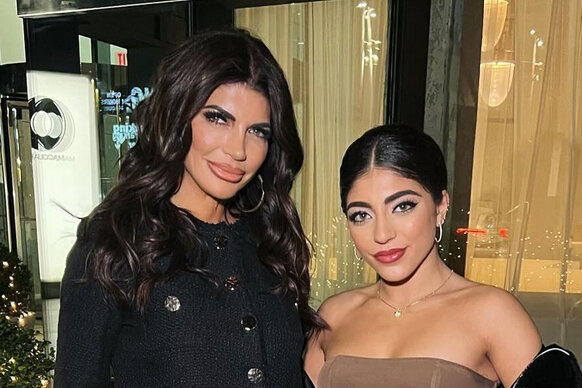 Teresa Giudice and Milania Giudice posing next to each other in front of a restaurant.