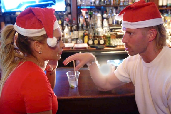 Lindsay Hubbard and Kyle Cooke at a bar wearing santa hats together.