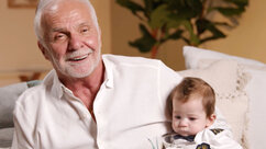 Captain Lee sitting on a couch holding Kate Chastain's son, Sullivan Chastain.