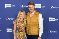 Cameran Eubanks and Shep Rose pose together in front of a step and repeat at BravoCon in New York City.