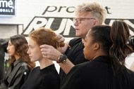 A stylist works on a model's hairstyle during an episode of Project Runway