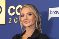 Taylor Ann Green smiling in a black top in front of the BravoCon 2022 step and repeat.