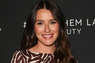 Kristina smiling in an animal print dress in front of a step and repeat.