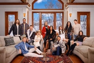 The cast of Winter House Season 3 all together in a living room in a snowy location.