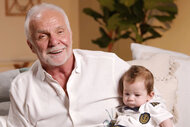 Captain Lee sitting on a couch holding Kate Chastain's son, Sullivan Chastain.