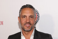 Mauricio Umansky smiling in a suit in front of a step and repeat.