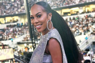 Sanya Richards-Ross smiling in front of an audience in a silver outfit.