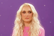 Erika Jayne wearing a pink dress and sitting in front of a purple backdrop.