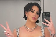 Katie Maloney posing in a mirror and making a peace sign.