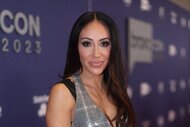 Melissa Gorga smiles in a silver jumpsuit/
