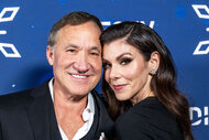 Heather Dubrow and Terry Dubrow posing together in front of a step and repeat.