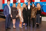 Kathy Hilton, Rick Hilton, Paris Hilton, Tessa Hilton, Barron Hilton, Farrah Brittany and Whitney Davis posing together in front of a screen.