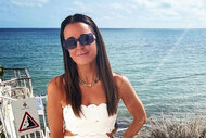 Kyle Richards wearing a white dress in front of the ocean.