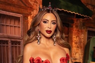Larsa Pippen wears a black, off shoulder, gown with rose applique in front of a Mexico City inspired set.