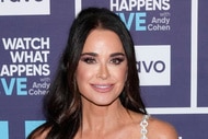 Kyle Richards smiling in front of a step and repeat at the Watch What Happens Live clubhouse in New York City.
