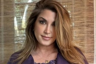 Jacqueline Laurita standing in front of a window in a purple outfit.