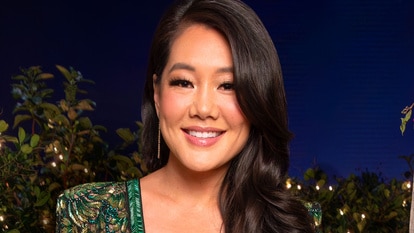 Crystal Kung Minkoff wearing a green dress in front of a Beverly Hills inspired set.