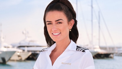 Aesha Scott wearing her yachting uniform on a boat marina