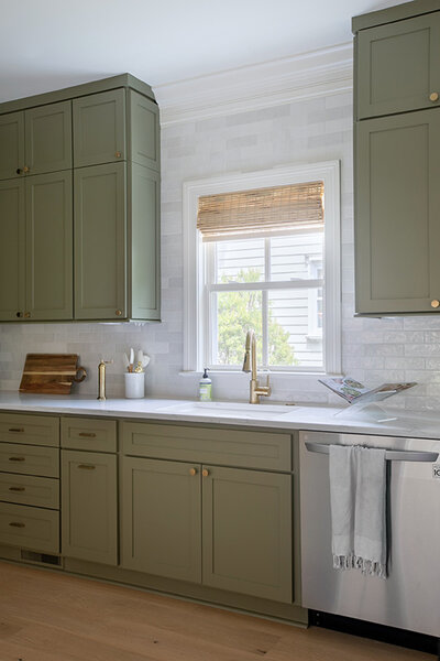 Madison LeCroy's olive toned kitchen cabinets, white wall tile, and gold hardware.