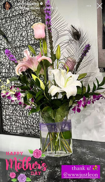 A vase filled with pink and white flowers sitting on a countertop.