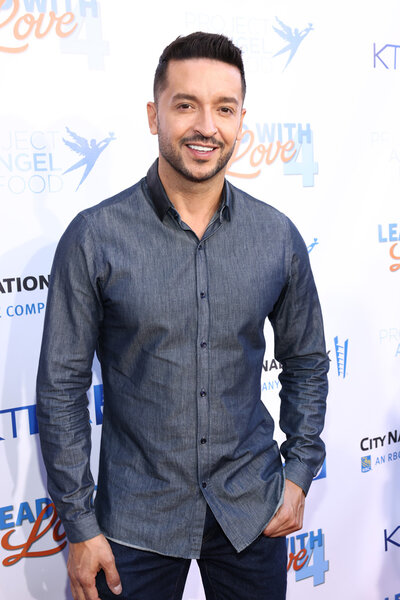 Jai Rodriguez poses for a photo on a red carpet.