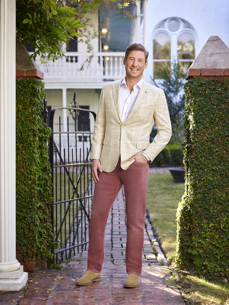 Austen standing outdoors in a beige blazer with salmon colored pants.
