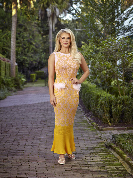Madison in a yellow, fitted, maxi dress outdoors.