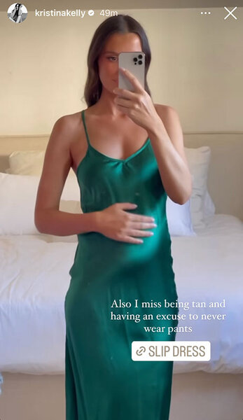 Kristina Kelly, pregnant, in an emerald green, silk, dress. Overlaid text: "Also I miss being tan and having an excuse to never wear pants".