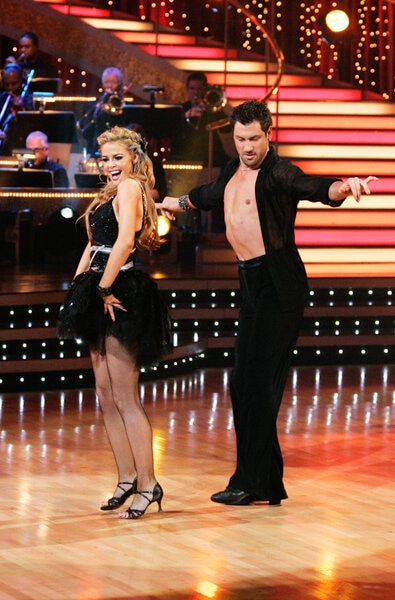 Denise Richards and Maksim Chmerkovskiy dancing together while competing on Dancing with the Stars.