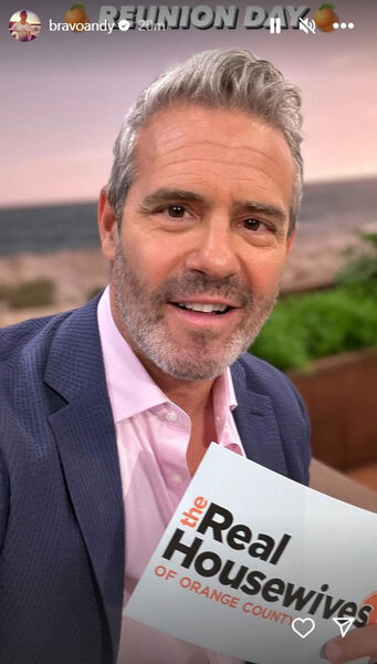 Andy Cohen at the RHOC Season 17 reunion holding up cue cards.
