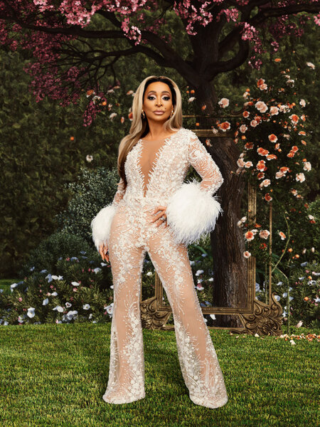 Karen Huger wearing a white lace jump suit in a garden.