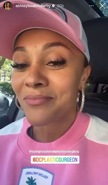 Ashley Darby sitting in a car wearing a pink hat and outfit.
